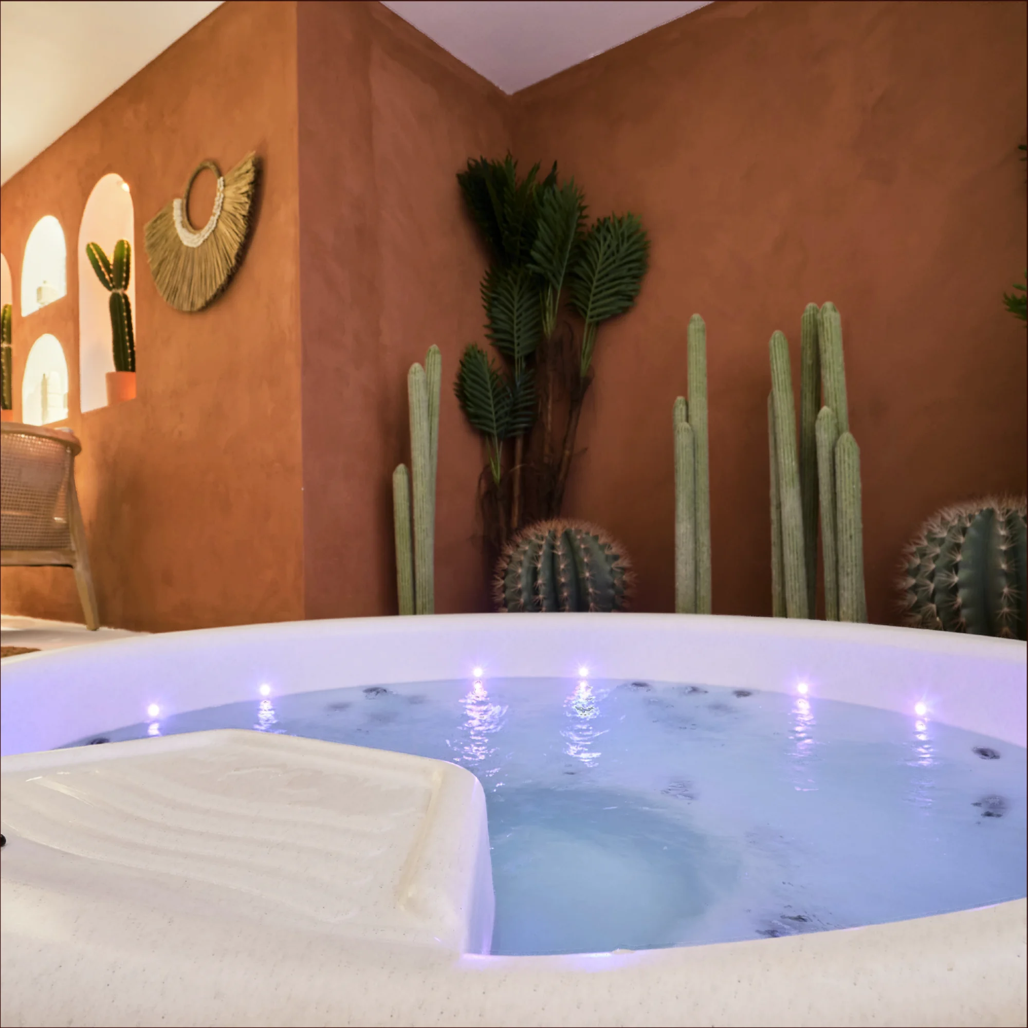 Espace jacuzzi Casa Del Spa : bain bouillonnant, cactus en arrière-plan, lumière mauve.