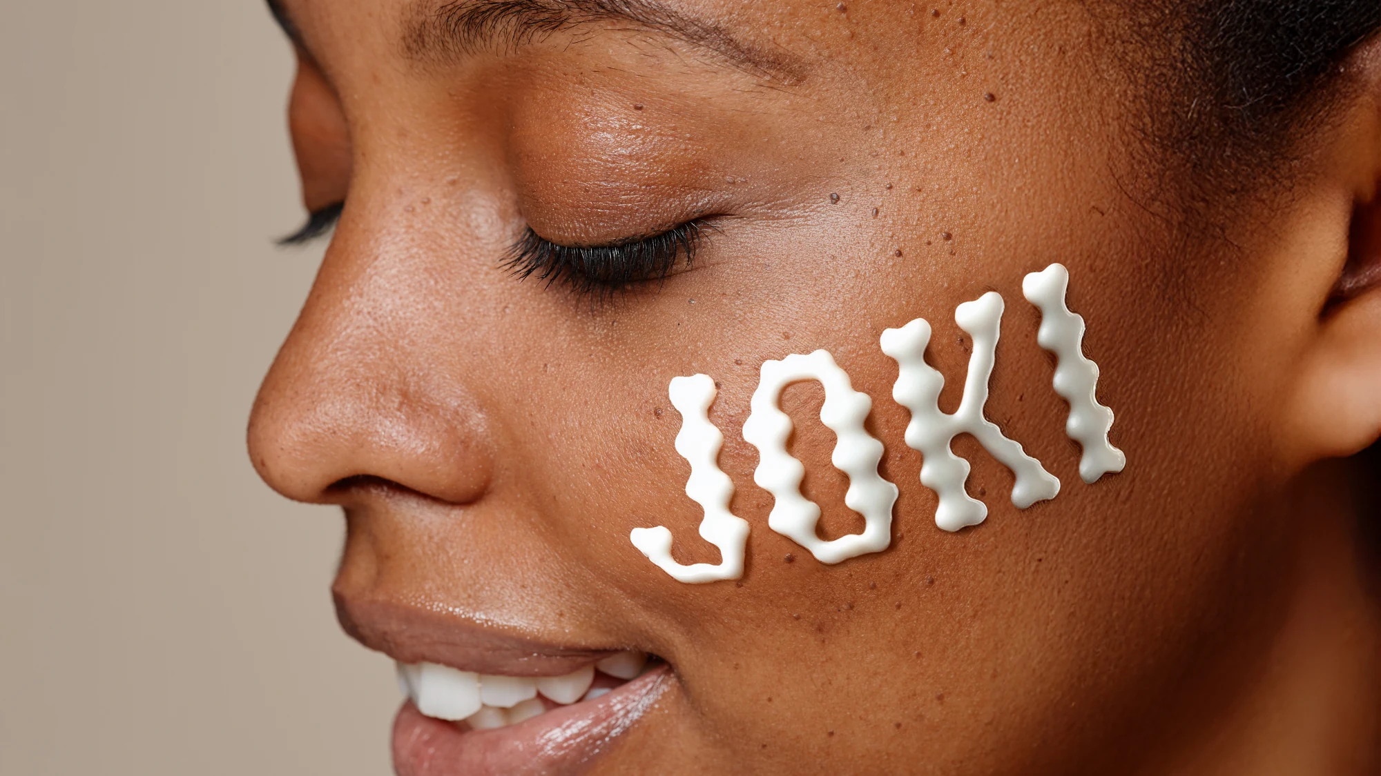 Joki, photo modèle avec wordmark crème sur la pommette, campagne skincare